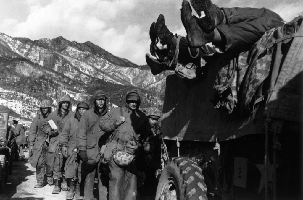 David Douglas Duncan - Marines File Past a Truck Load with Dead Troops during Retreat from Chosin Reservoir